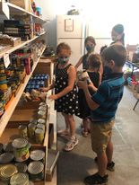 kids stocking food pantry shelves